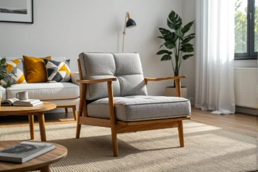 Szary fotel wypoczynkowy z drewnianymi podłokietnikami i ramą